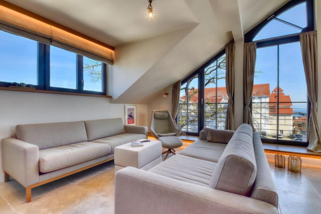 a living room with two couches and large windows at Penthouse 7 Villa Martha in Binz