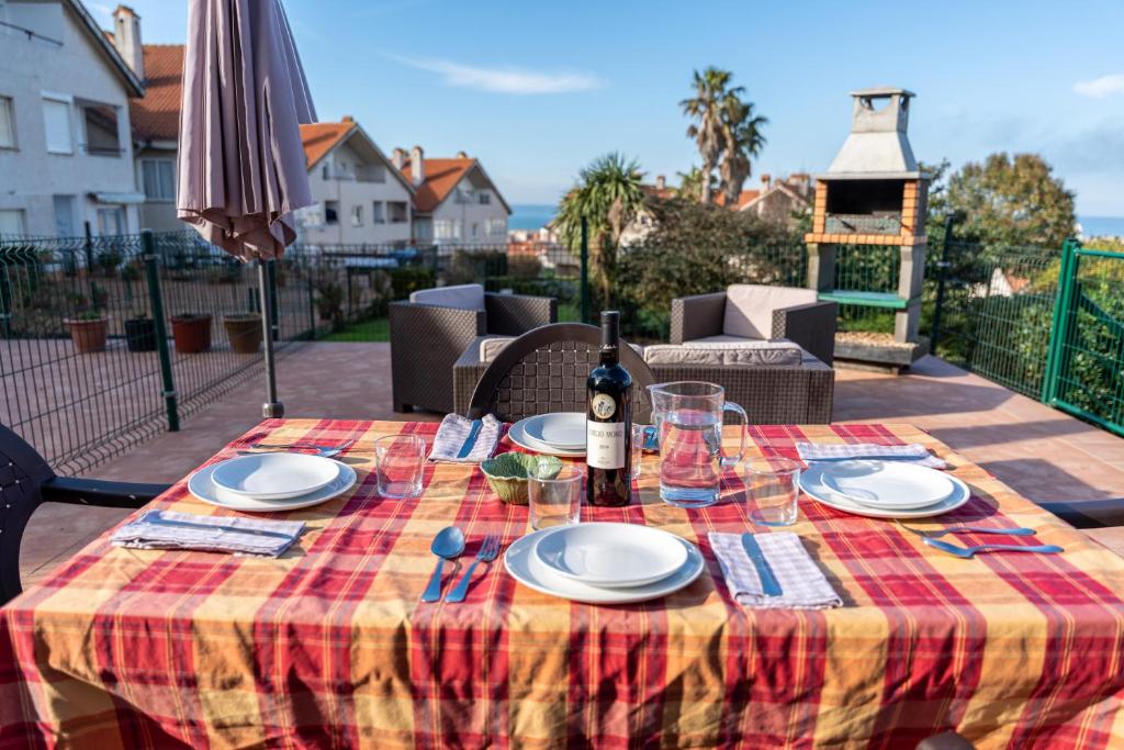 a table with a bottle of wine and plates on it at La Caleta de Mogro in Mogro
