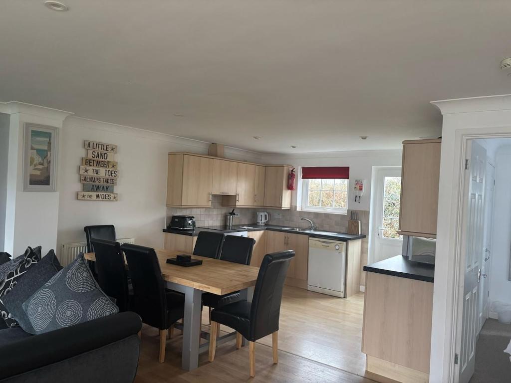 eine Küche und ein Esszimmer mit Tisch und Stühlen in der Unterkunft Cornwall Lodge sleeps 8 full Holiday Park Access in Saint Columb Road Station