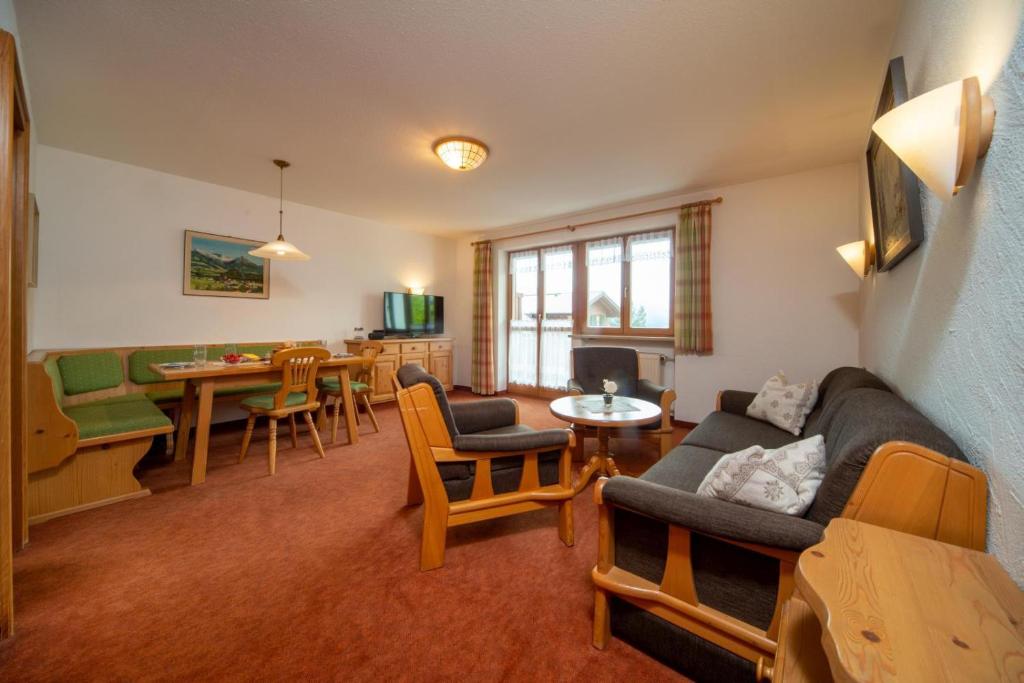 una sala de estar con un sofá y una mesa en Allgäuer Bergblick, en Fischen