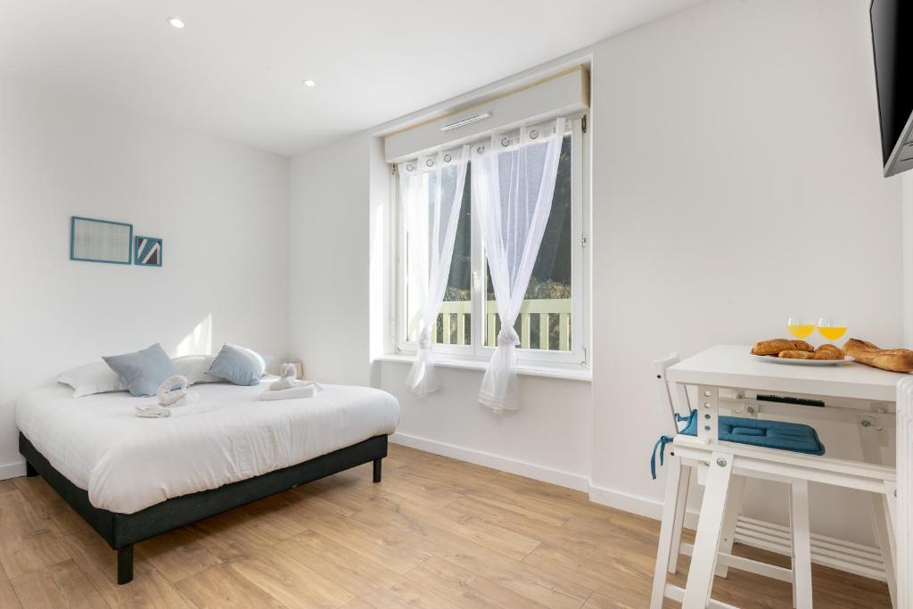 une chambre blanche avec un lit et une fenêtre dans l'établissement Chambre indépendante Bellepoule, à Brest