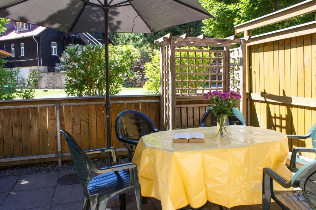 a table with chairs and an umbrella on a patio at Ferienwohnung Ferienhäuser am Brocken, 60 qm 2 Schlafzimmer in Ilsenburg