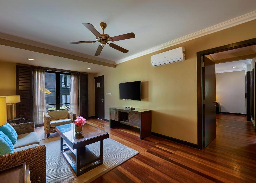 a living room with a couch and a ceiling fan at The Taaras Beach & Spa Resort in Redang Island
