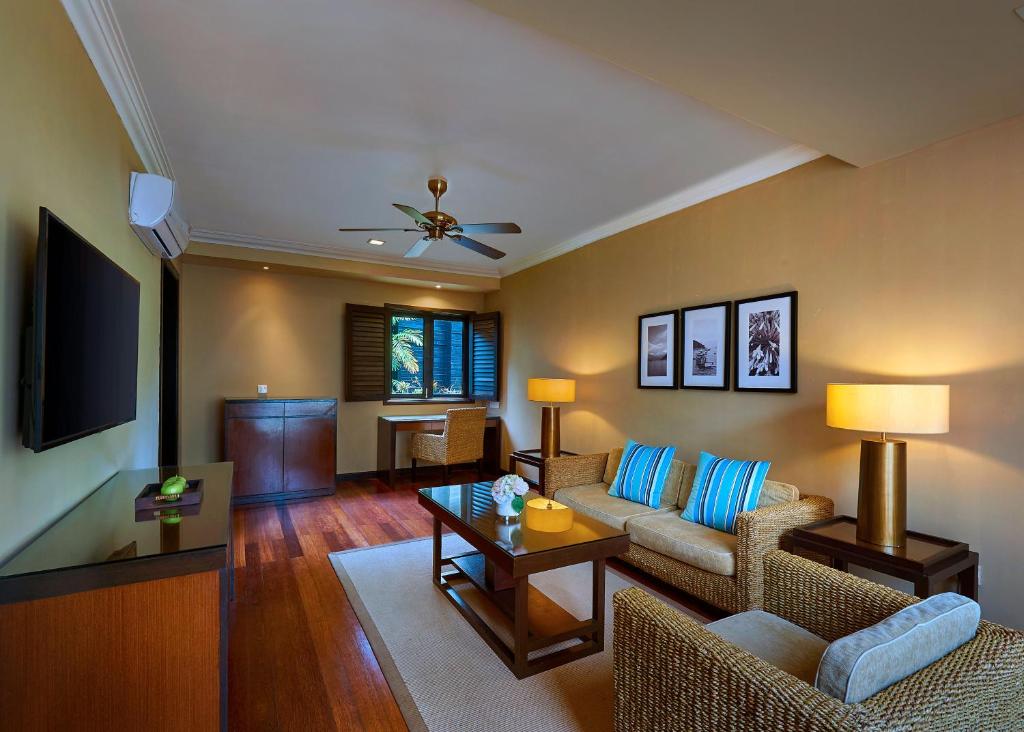 a living room with a couch and a tv at The Taaras Beach & Spa Resort in Redang Island