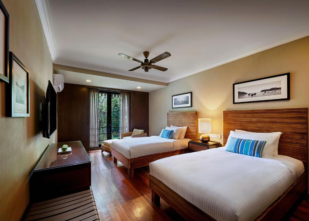 a hotel room with two beds and a ceiling fan at The Taaras Beach & Spa Resort in Redang Island
