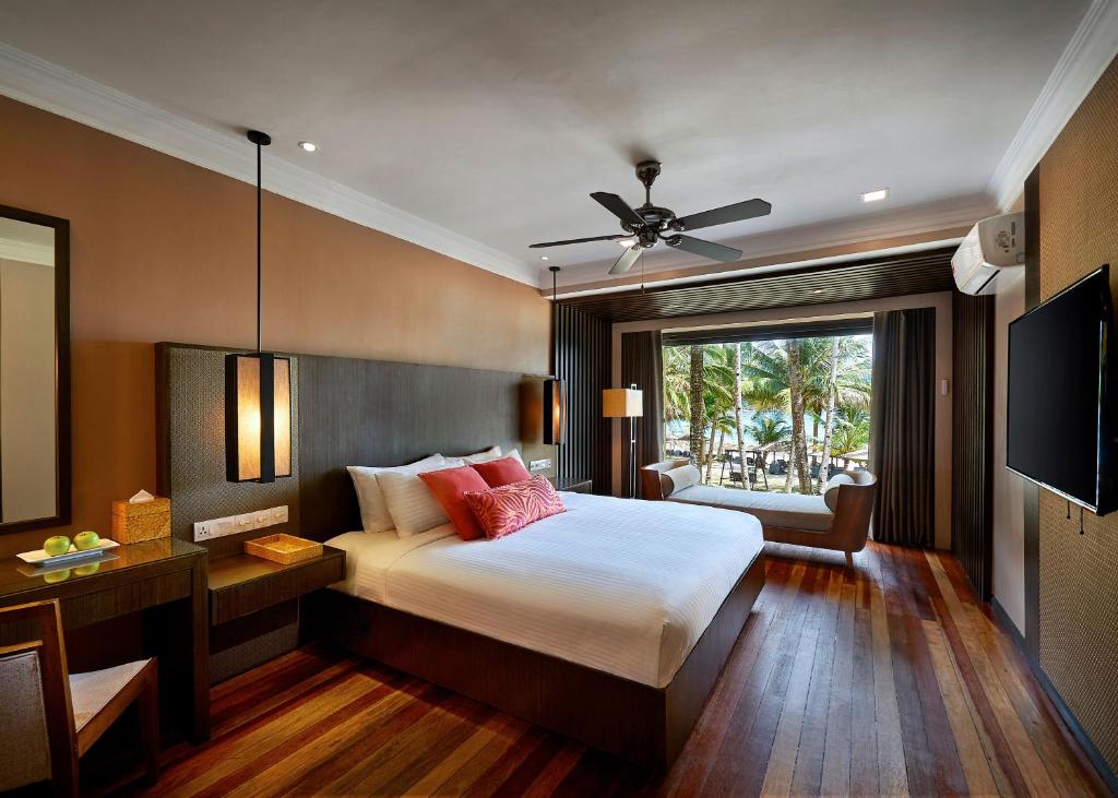 a bedroom with a large bed and a television at The Taaras Beach & Spa Resort in Redang Island