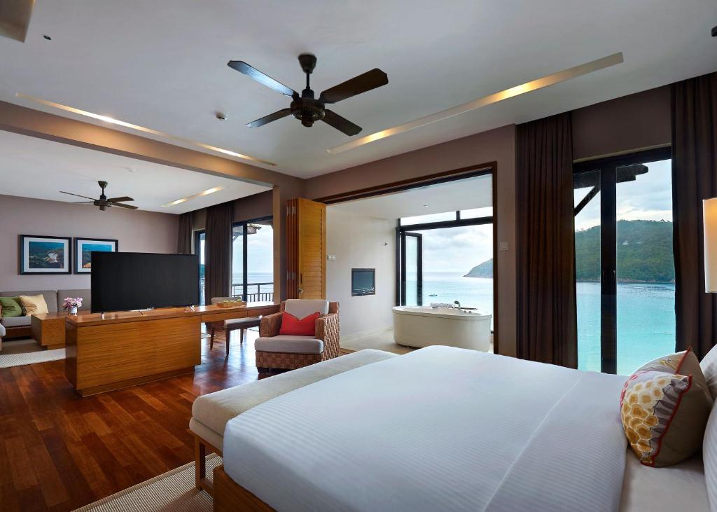 a bedroom with a bed and a television in a room at The Taaras Beach & Spa Resort in Redang Island