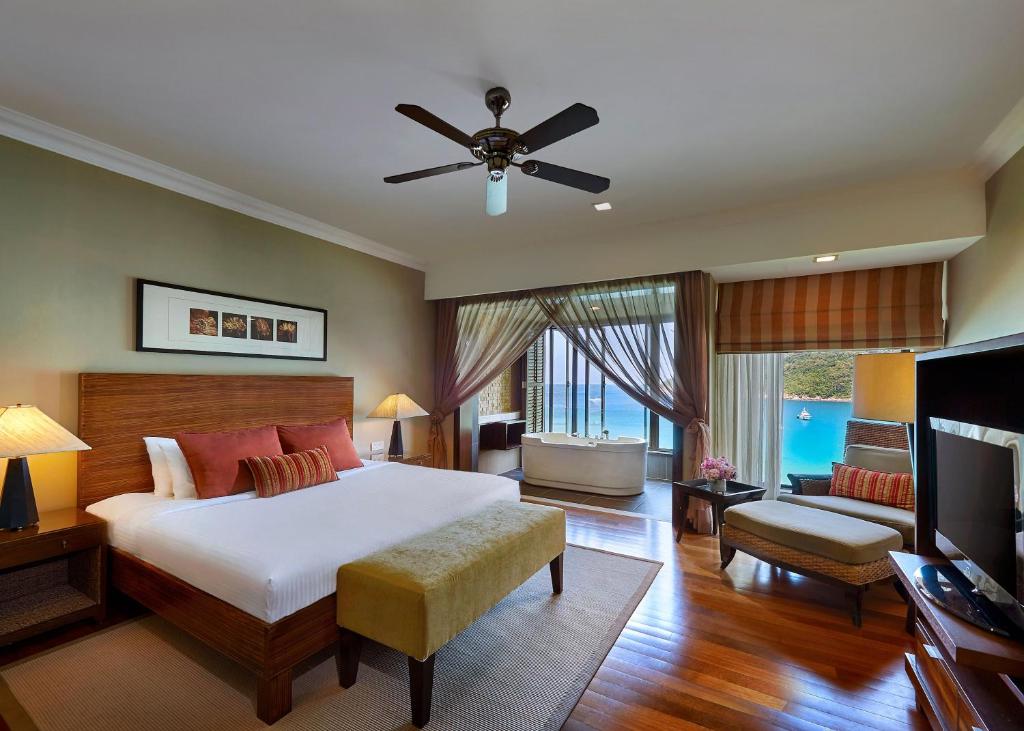 a bedroom with a large bed and a television at The Taaras Beach & Spa Resort in Redang Island