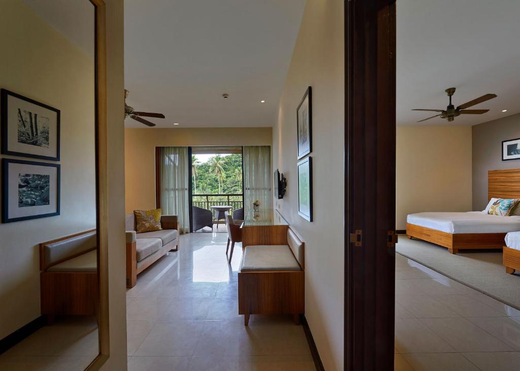 a bedroom with a bed and a living room at The Taaras Beach & Spa Resort in Redang Island