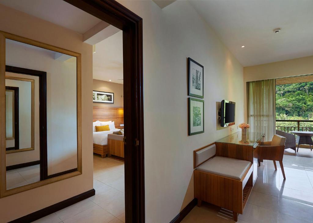 a room with a bed and a desk and a mirror at The Taaras Beach & Spa Resort in Redang Island