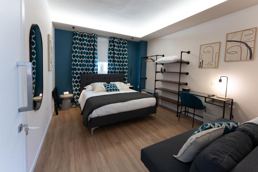 a bedroom with two beds and a couch in it at Tre Gemme in Centro - Suite Azure in Pescara
