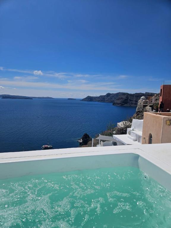 a swimming pool with a view of the ocean at Phaos Oia Suites in Oia