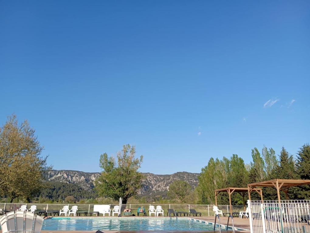- une piscine avec un kiosque, des tables et des chaises dans l'établissement Mobil-Home Provence, à Cheval-Blanc