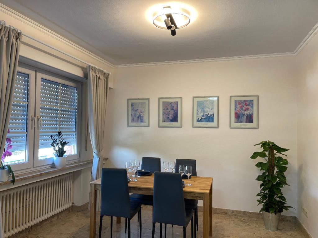 una sala da pranzo con tavolo in legno e sedie blu di 暖暖屋 a Mamer