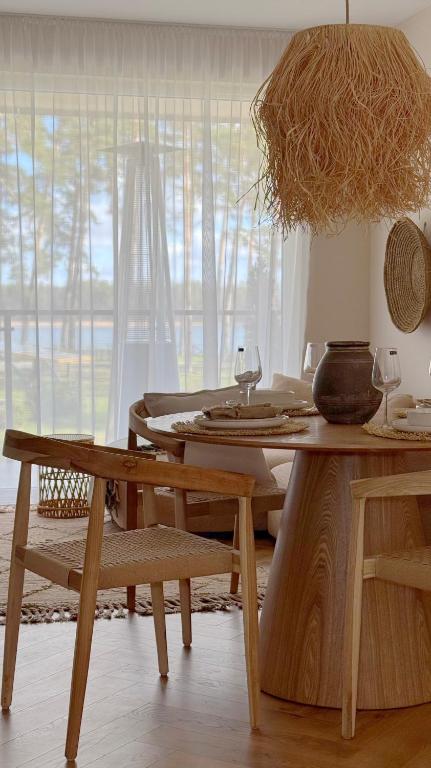 a dining room with a table and chairs and a window at Apartamenty Cisza Natury - BRYZA in Augustów