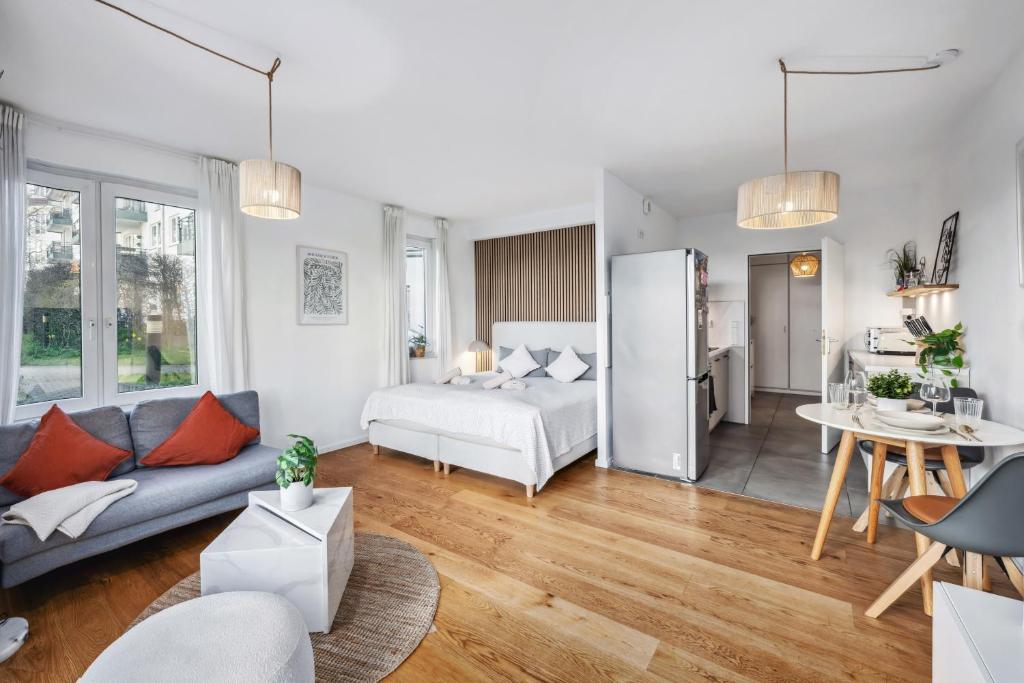 een woonkamer met een bank en een koelkast bij TRABER APARTMENTS Studio Kaffee Terrasse & Parken in Leipzig