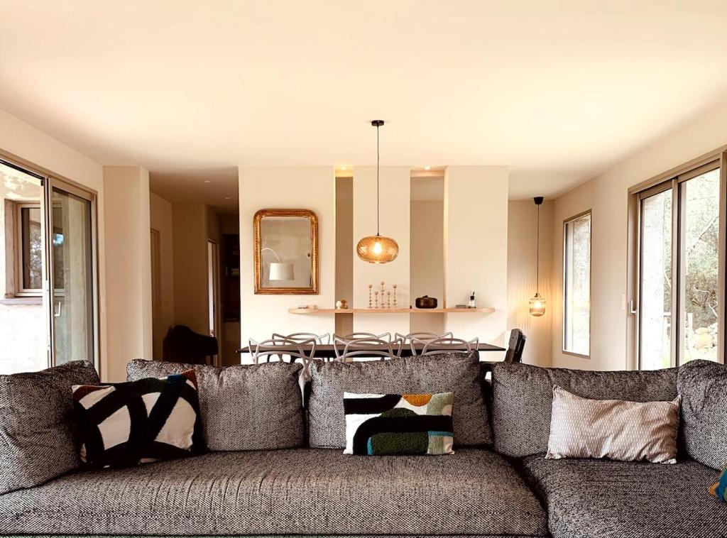 un salon avec un canapé avec des oreillers dans l'établissement Villa de Standing avec vue montagne, proche de Porto-Vecchio, à Porto-Vecchio