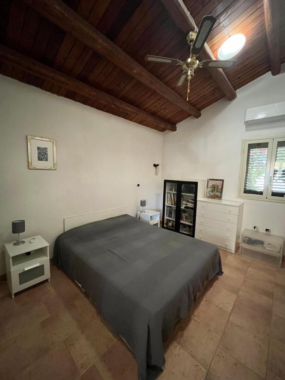 Un dormitorio con una cama y un ventilador de techo. en La Casa del Carrubo con Piscina condivisa in campagna vicino al mare - Canestanco 18, en Santa Croce Camerina