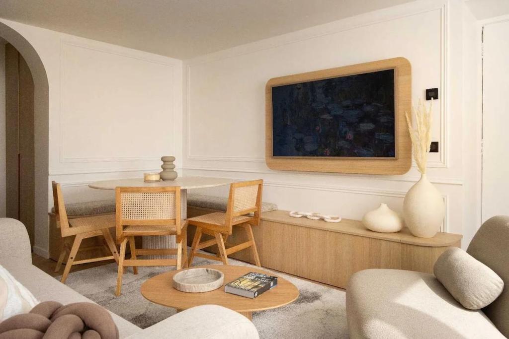 un salon avec une table et un canapé dans l'établissement Chic Apartment with AC 3BR 6P Palais Garnier, à Paris
