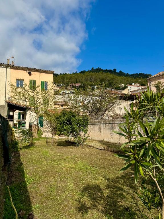- une vue sur une cour avec un bâtiment et des arbres dans l'établissement Charmante maison Provençale, à Solliès-Toucas