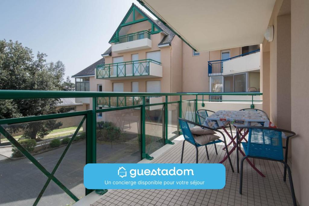 a balcony with a table and chairs in front of a building at LE VINTAGE - 300m plage - Wifi - Parking in Saint-Nazaire