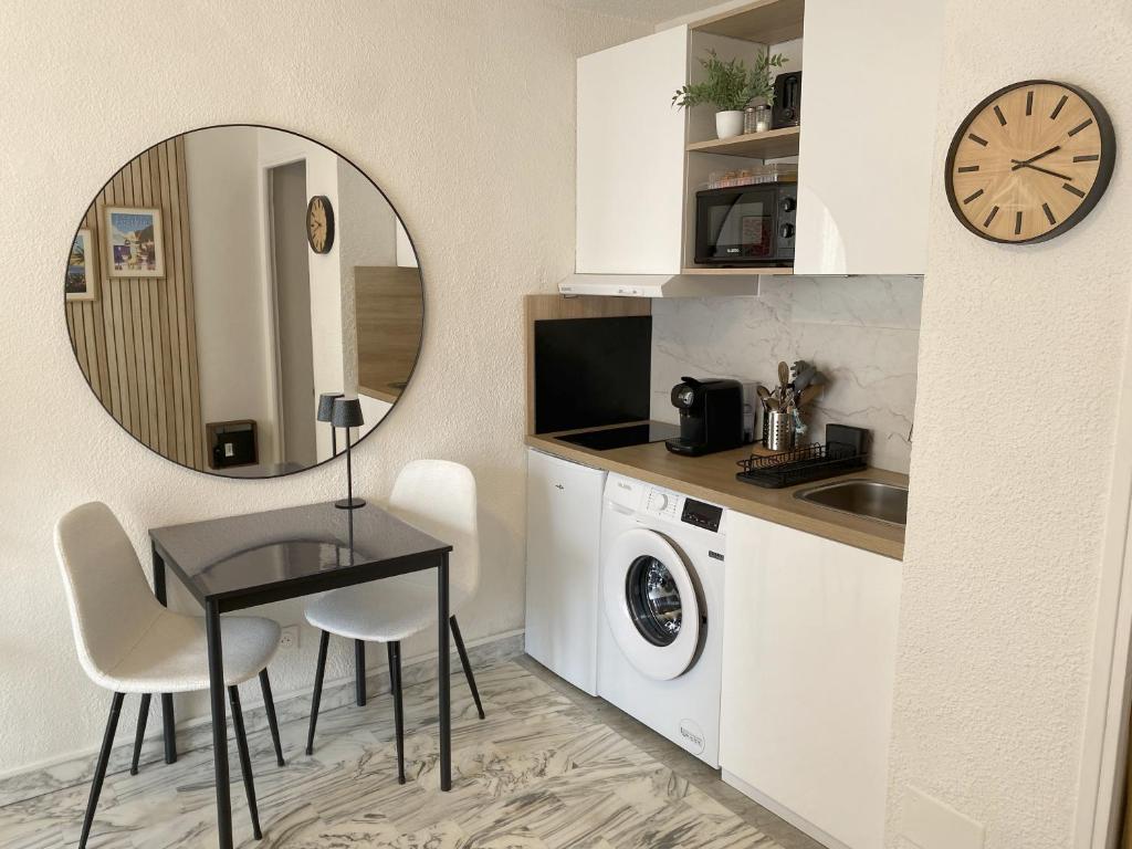 - une cuisine avec une table, un évier et un miroir dans l'établissement A deux pas des plages et au coeur du vieil Antibes , beau studio rénové, à Antibes