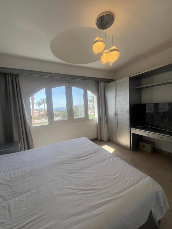 une chambre avec un lit blanc et une grande fenêtre dans l'établissement classy new 2 bedrooms 2 bathrooms apartment at Domina coral bay sea view with everything you need, à Charm el-Cheikh