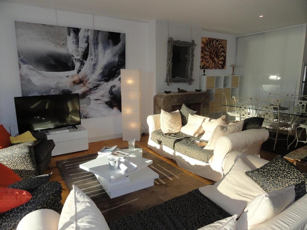 a living room with white couches and a flat screen tv at Appartement Pyla Les Cèdres in Pyla-sur-Mer