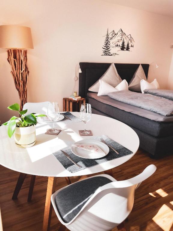 a living room with a table and a bed at Ferienwohnungen Kaiser Franz in Krün