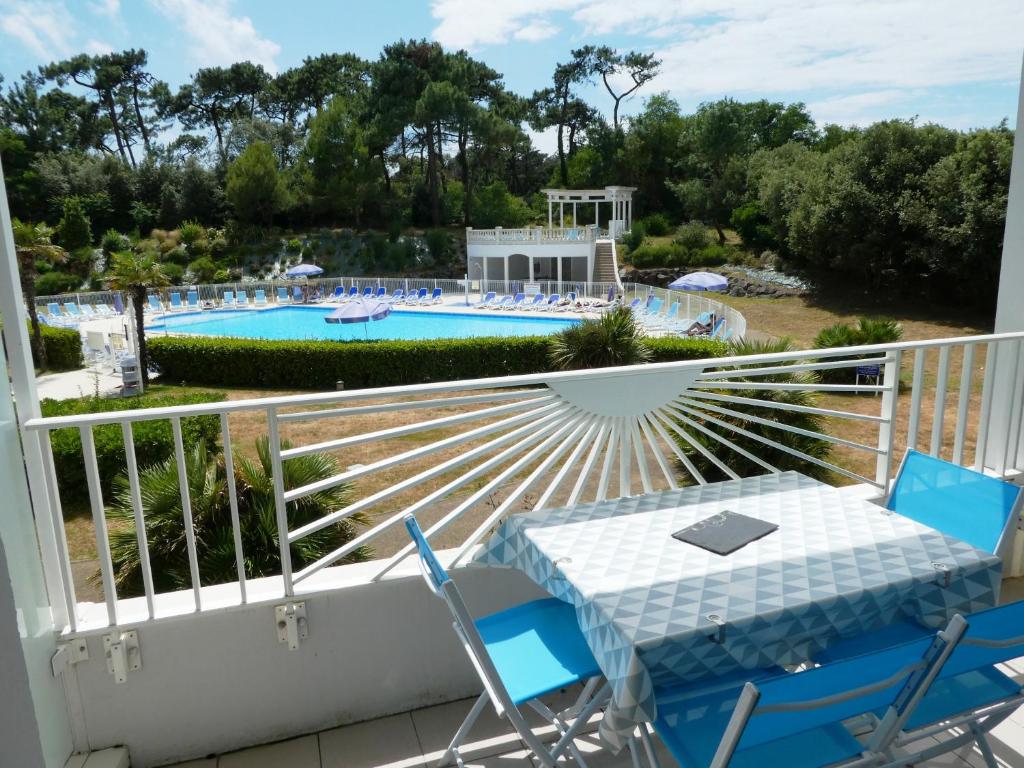 d'un balcon avec une table et des chaises, ainsi que d'une piscine. dans l'établissement Les Sables superbe T3 cadre unique 7mn à pied de la mer, à Les Sables-dʼOlonne