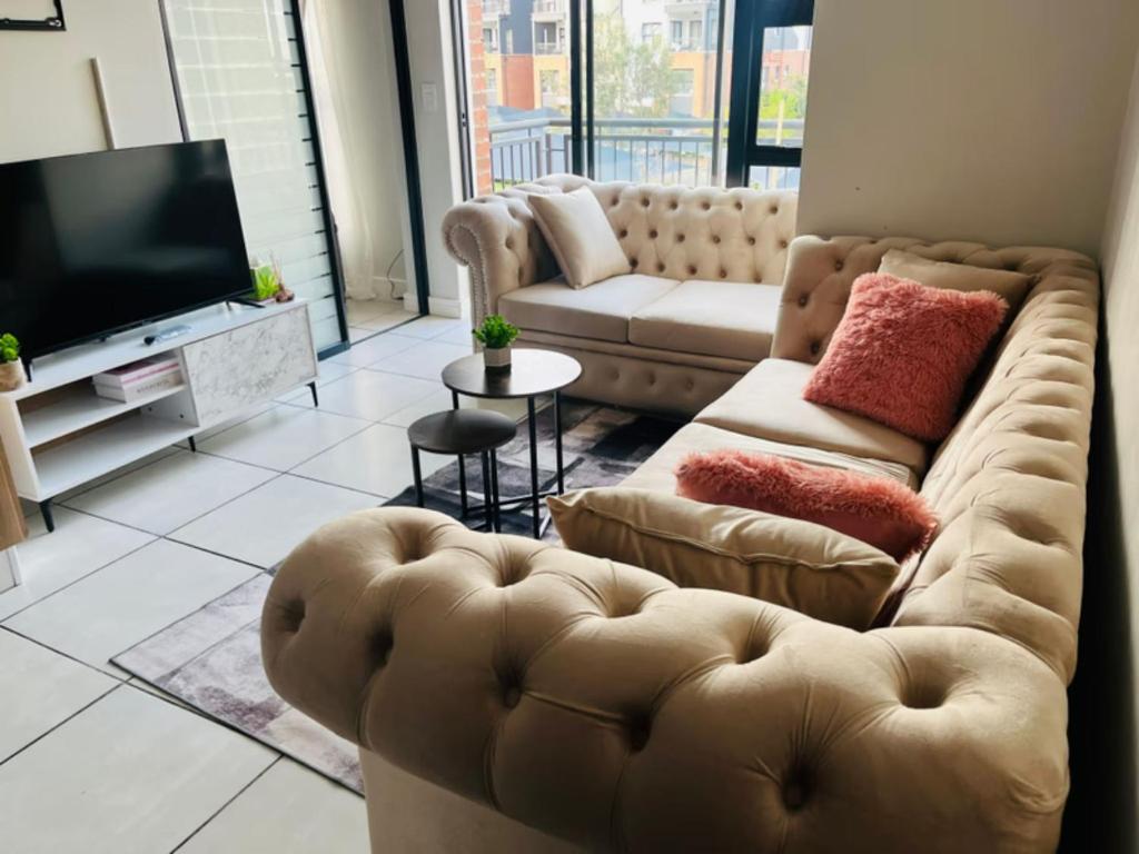a living room with a couch and a television at Cozy Pretoria Apartment with City Garden Views in Pretoria
