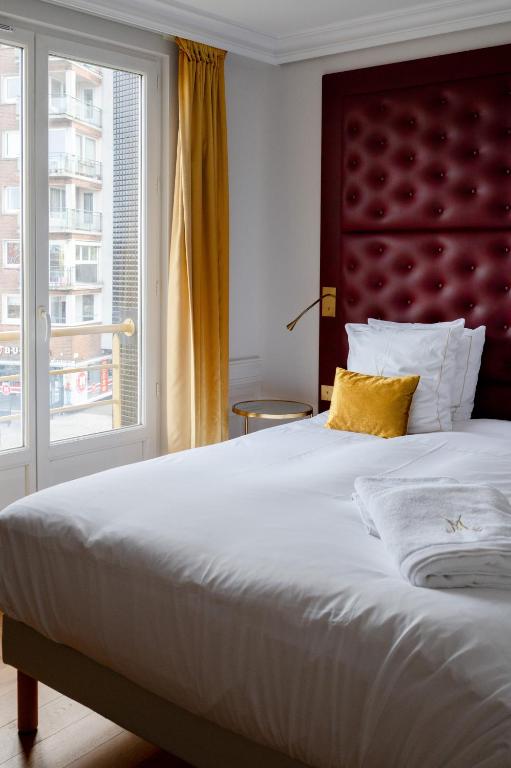 a bedroom with a large bed with a large window at Les chambres du Waterzooi in Dunkerque