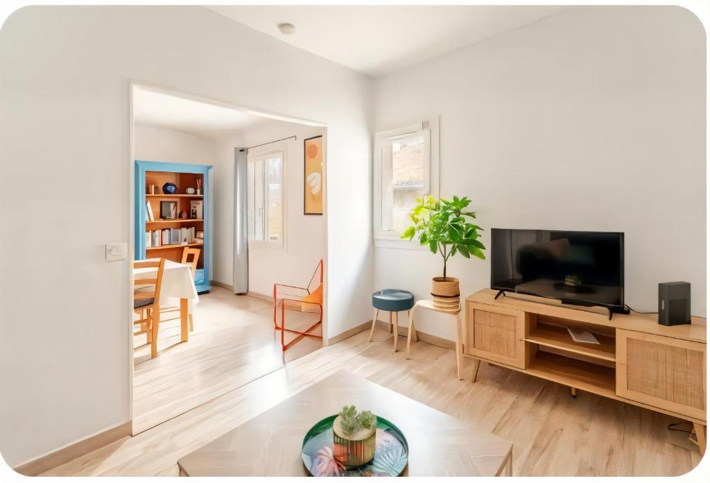 - un salon avec une télévision à écran plat dans un centre de divertissement en bois dans l'établissement L'appartement de la Roquette centre historique Arles, à Arles