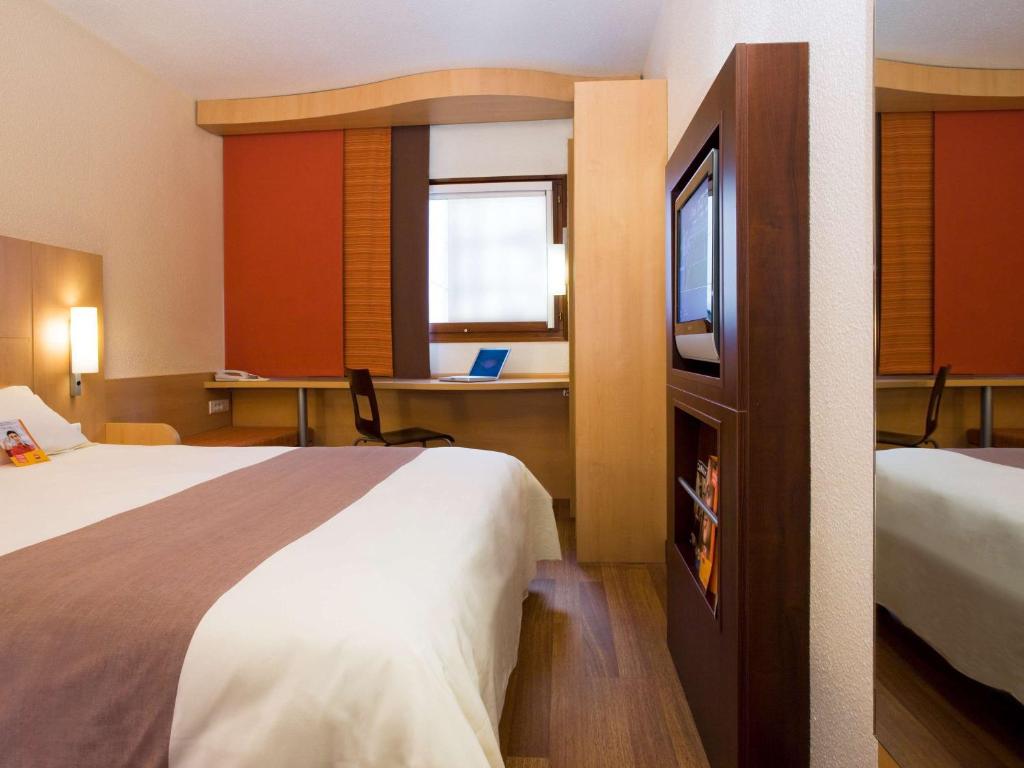 a hotel room with a bed and a desk at Hotel Ibis Lisboa Sintra in Sintra