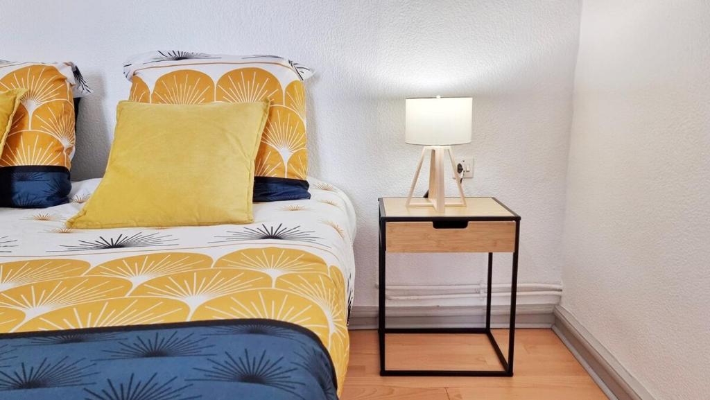 - une chambre avec un lit et une table de chevet avec une lampe dans l'établissement Loft lumineux près du port du canal, à Colmar