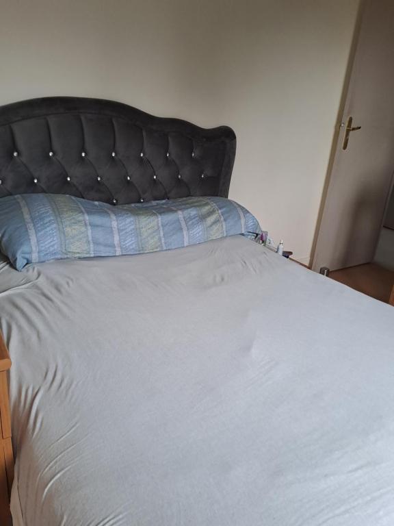 - un grand lit avec un oreiller bleu dans l'établissement Élégant apartment, à Tremblay-en-France