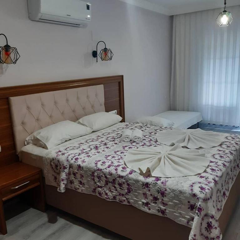 a bedroom with a bed with a floral bedspread at Yuvarlakçay pınar Otel in Köyceğiz
