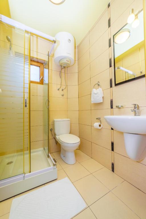 a bathroom with a shower toilet and a sink at Hotel Odissey Jaz in Budva