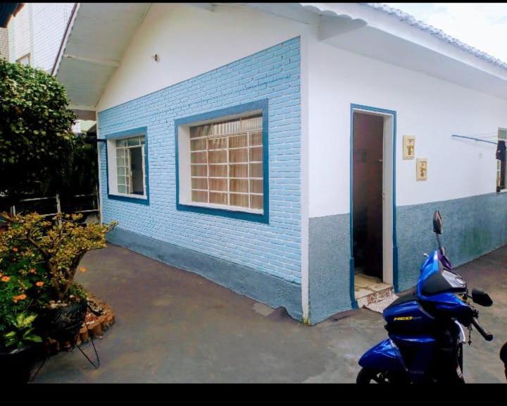 een blauw gebouw met een scooter ervoor geparkeerd bij Hostel Mi casa su casa in Poços de Caldas