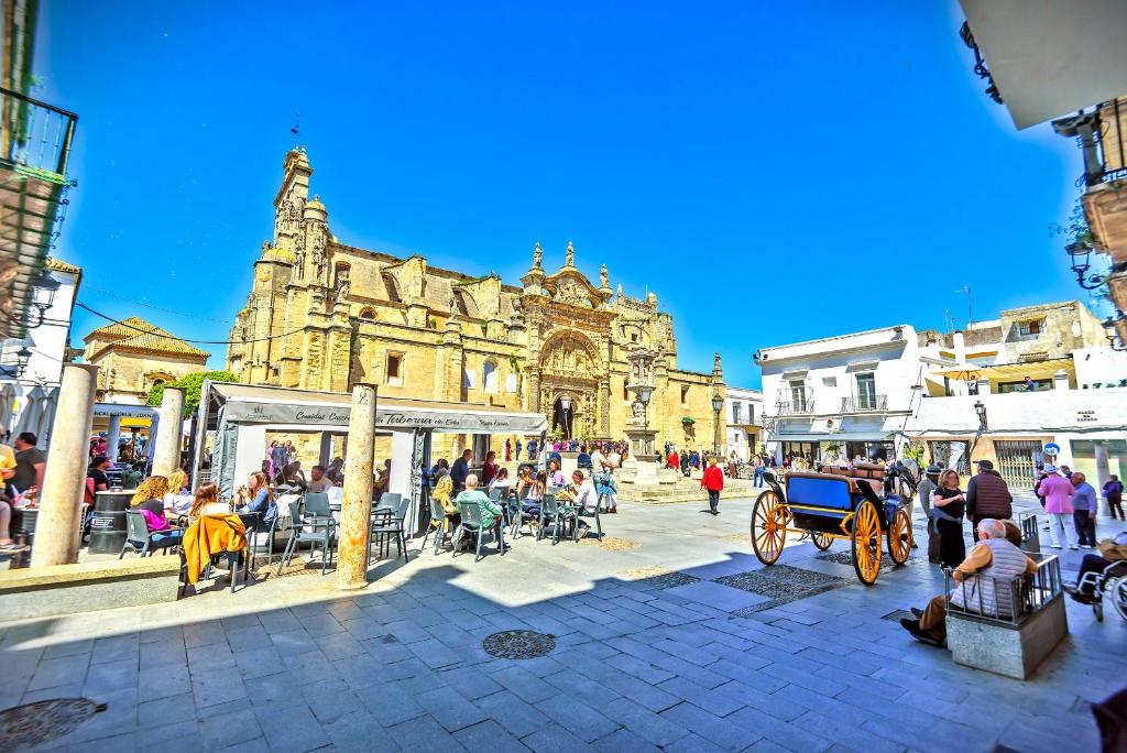 a street with a horse drawn carriage in front of a building at Plaza España 3-bedroom central & bello apartamento in El Puerto de Santa María