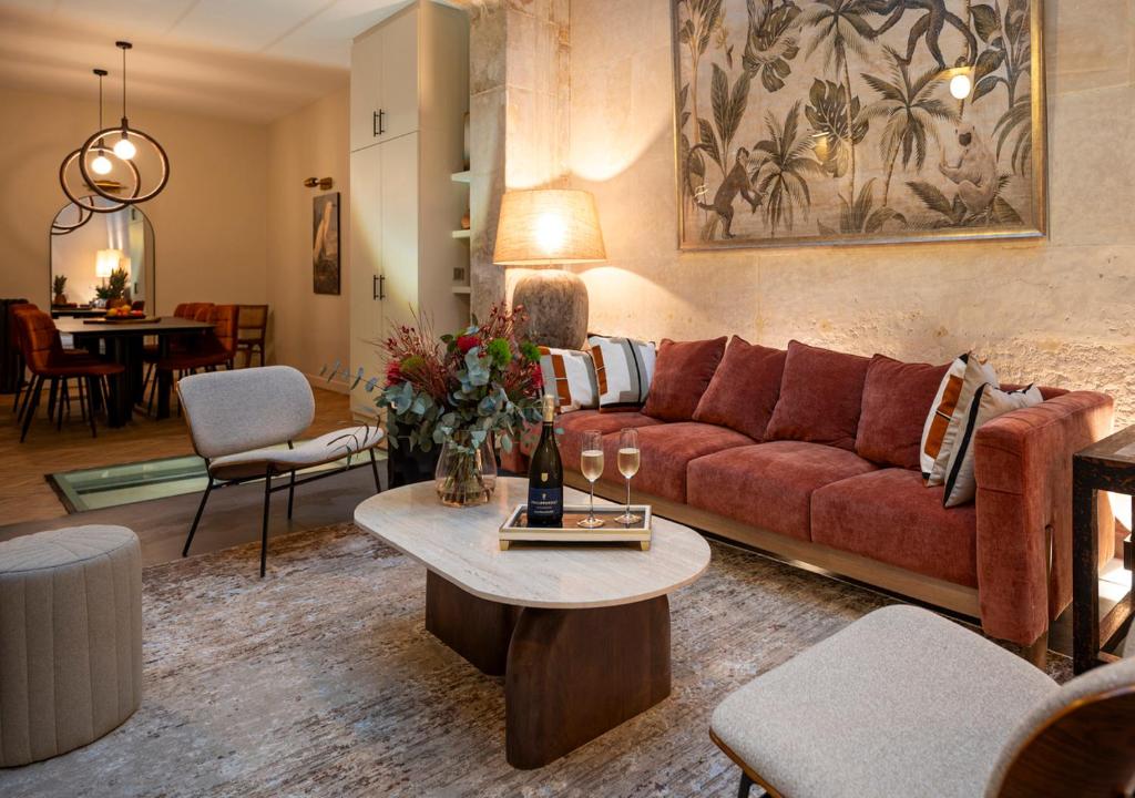 un salon avec un canapé rouge et une table dans l'établissement L'Atelier des Arts, à Paris