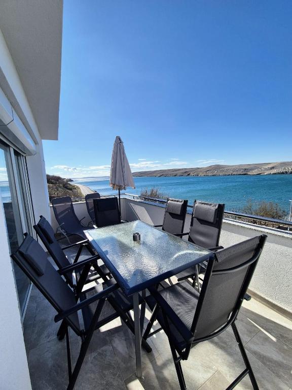 a table and chairs on a balcony with the ocean at Apartment Perla in Dinjiška