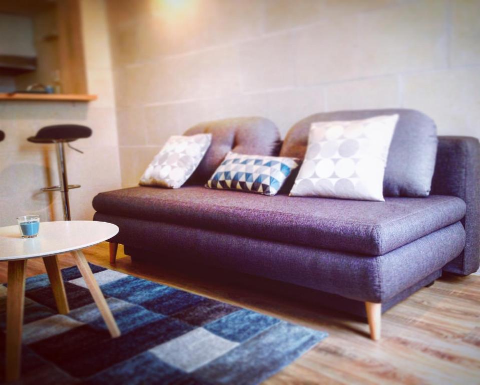 un sofá púrpura con almohadas en la sala de estar en Sweet Morning Bordeaux, en Burdeos