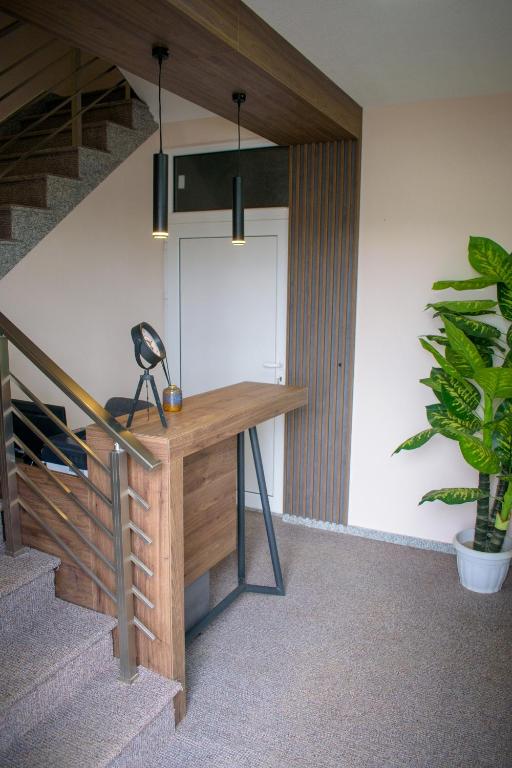 a desk in a room with stairs and a plant at Prenoćište Binta in Vranje