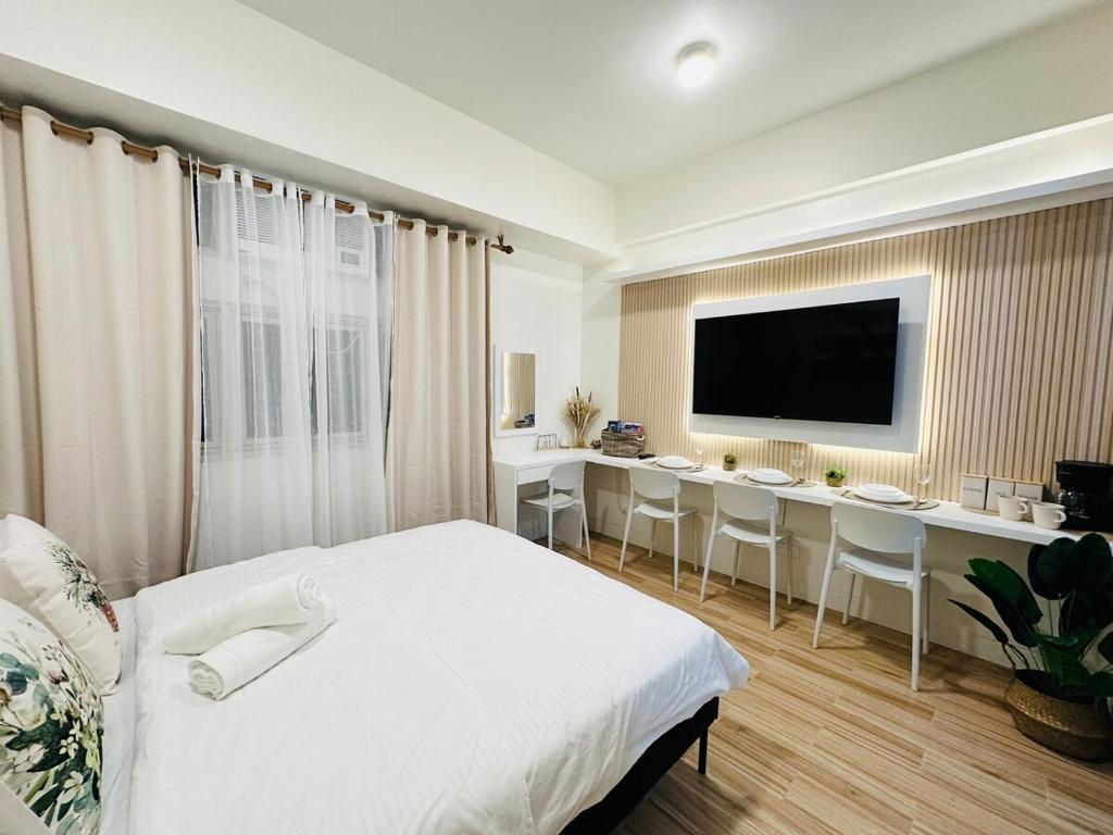 BiñanにあるGetaway Haven at Southwoods, Biñan with Fast Internetのベッドと机とテレビのある寝室