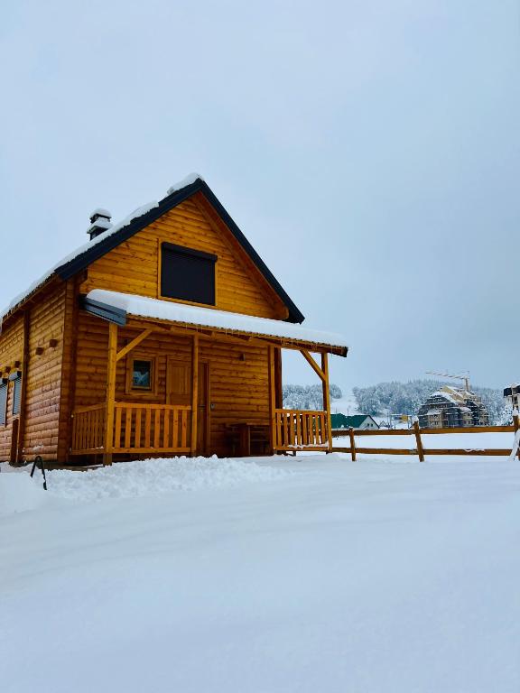 a log cabin with snow on the ground at Alfa Omega Žabljak in Žabljak