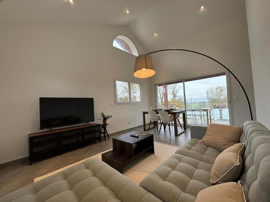 ein Wohnzimmer mit Couch und Flachbildfernseher in der Unterkunft Le spacieux au dernier étage avec vue dégagée in Arthaz-Pont-Notre-Dame
