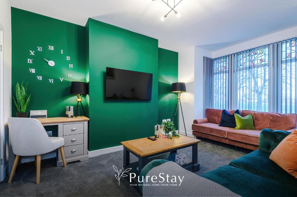 a living room with a green accent wall at Beautiful Bradford 3 Bedroom Home Sleeps 8 with Parking by PureStay in Wibsey