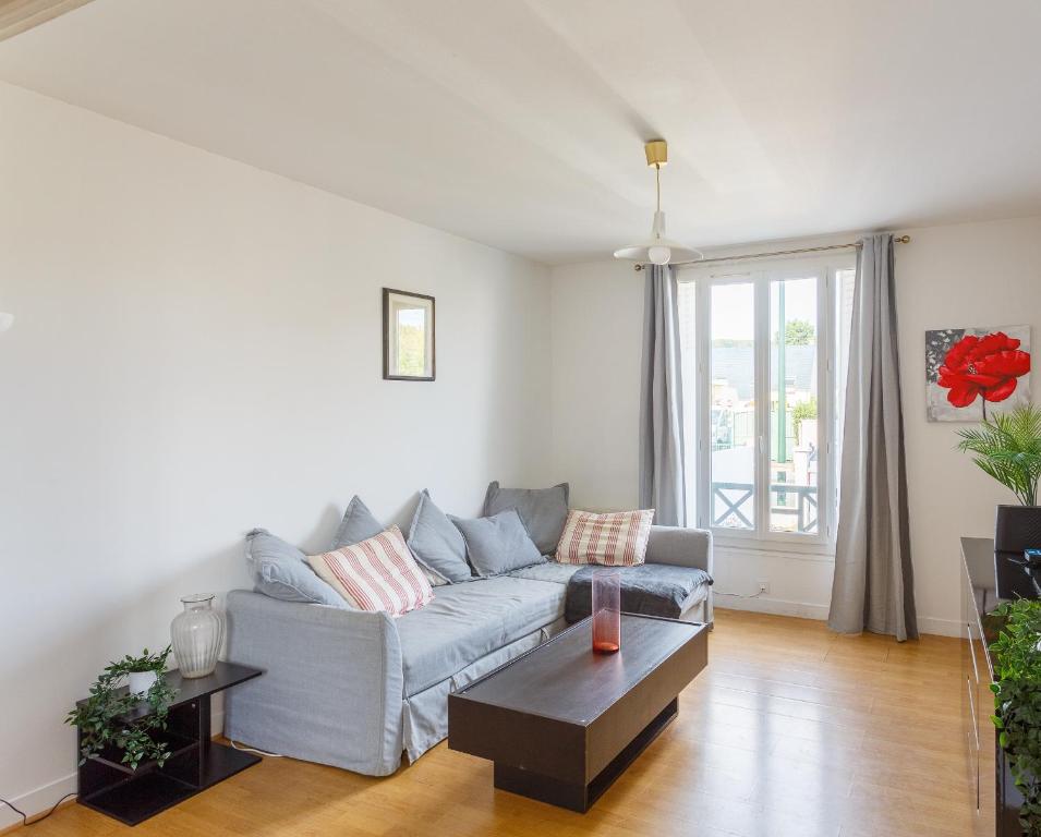 un salon avec un canapé et une table dans l'établissement La Maison Kokliko - Maison pour 4, à Saint-Leu-la-Forêt