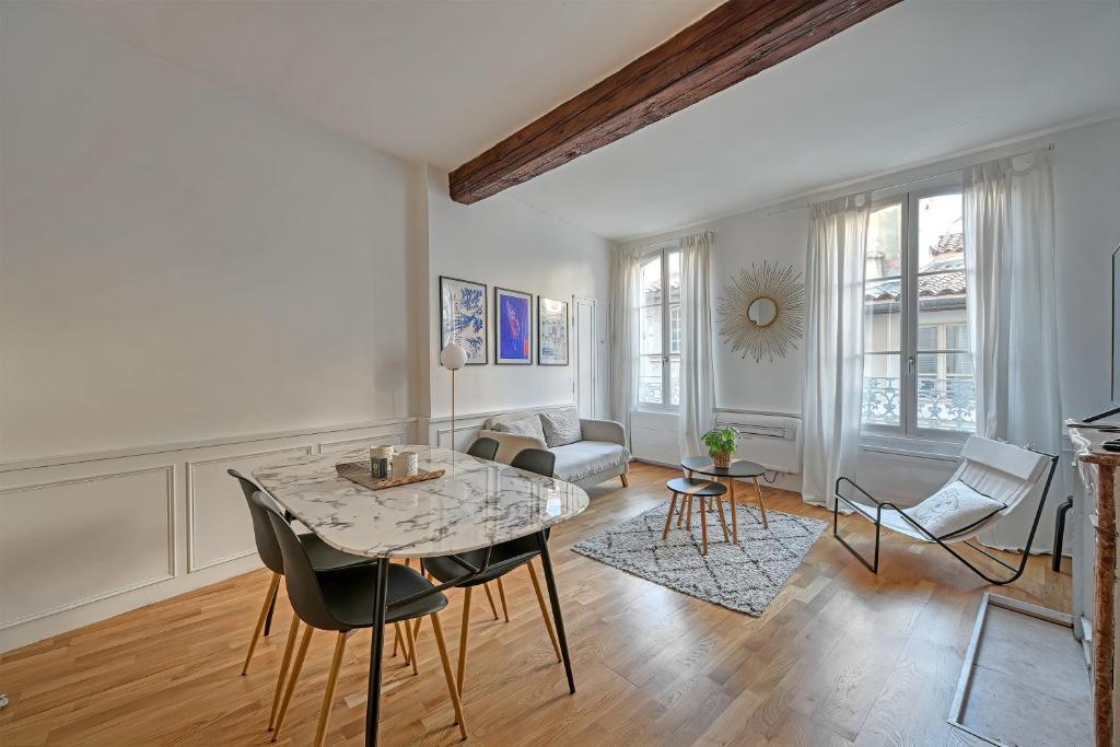 un salon avec une table et des chaises dans l'établissement Le Madaloca - AC CLIM - WIFI - HYPERCENTRE, à Avignon